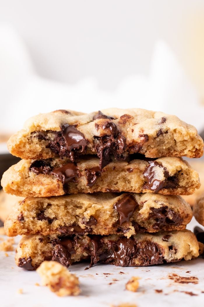 s die view of a stack of chocolate chip cookies cut in half, chocolate oozing out